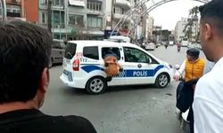 Gözaltına alınan zanlının polis aracının camından kaçmaya çalışması kameraya yansıdı